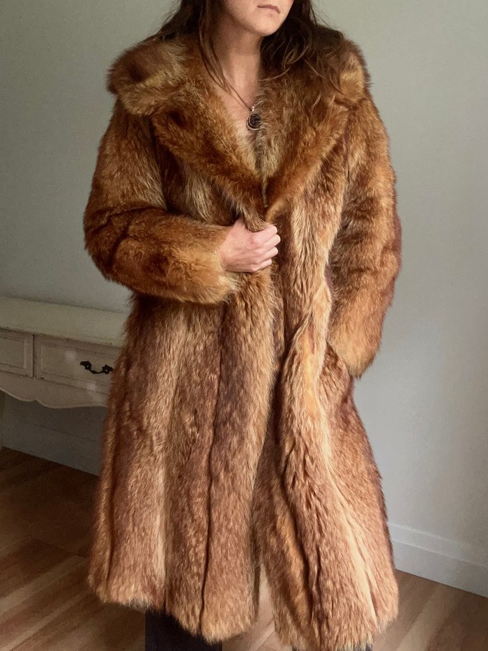 Anita wearing a full-length vintage fur coat with a pendant necklace